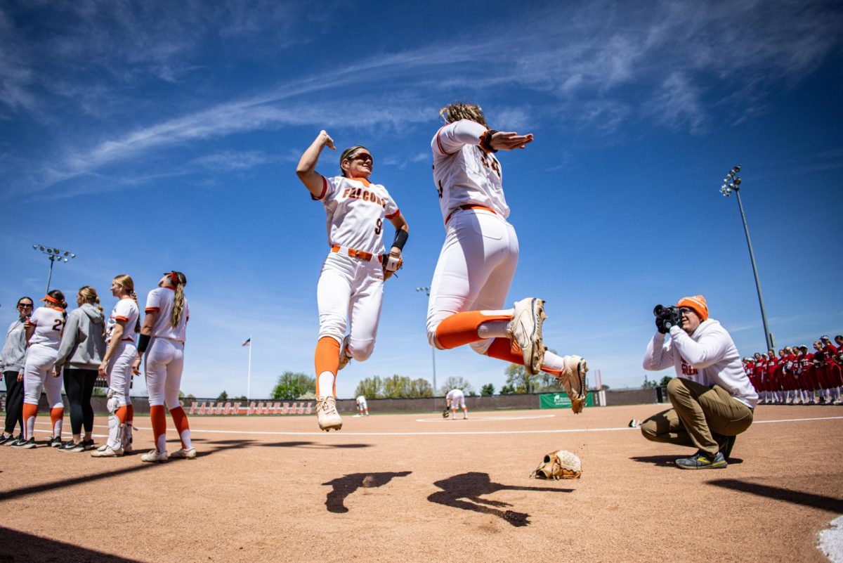 Bowling Green, OH - Falcons sophomore first base Taylor Behrendt (9) and senior pitcher Scarlet Anderson (34) jump in the air as part of player introductions prior to a matchup against the Miami RedHawks at Meserve Field in Bowling Green, Ohio.